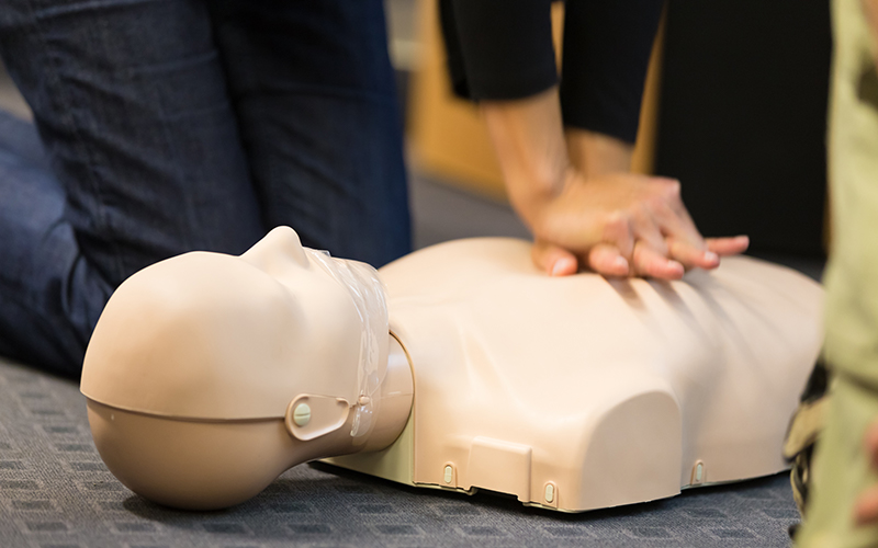 Close up of person practicing CPR on dummy